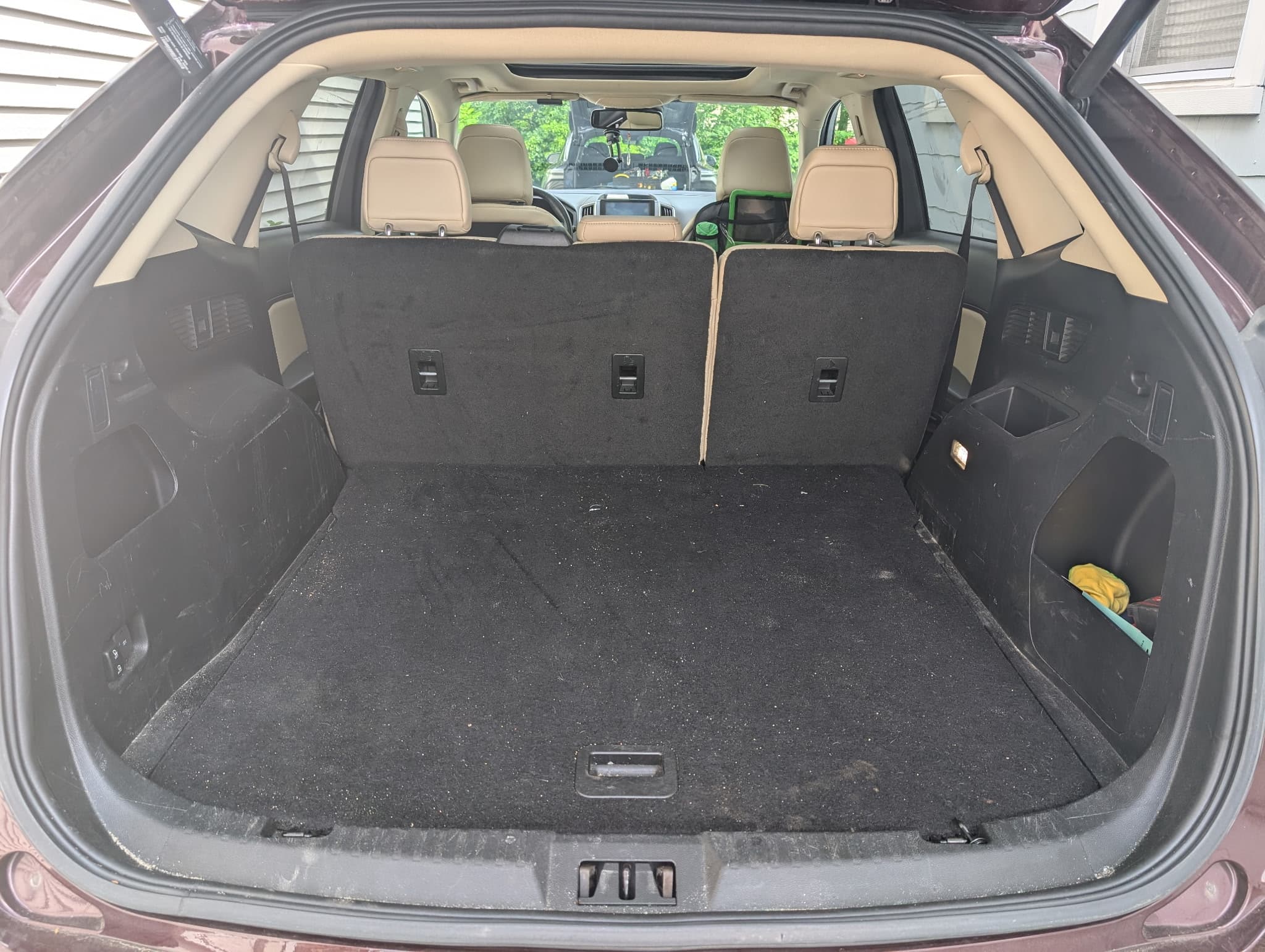 Trunk area before cleaning showing dust and lint